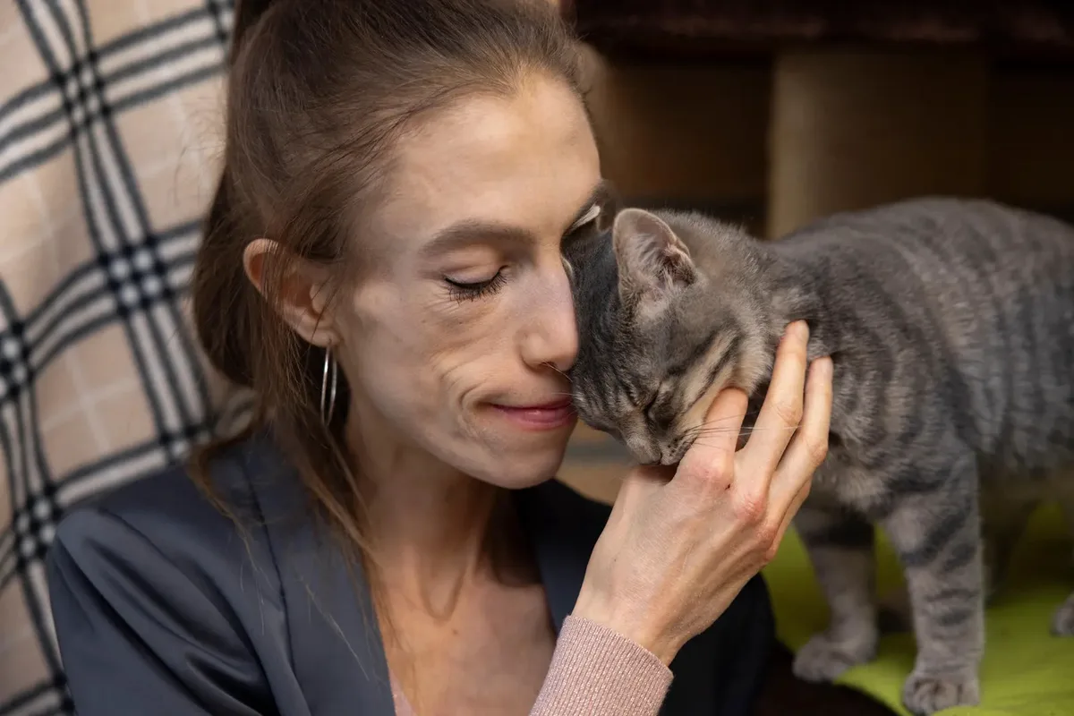 Man sieht Meret Schneider neben einer Katze.